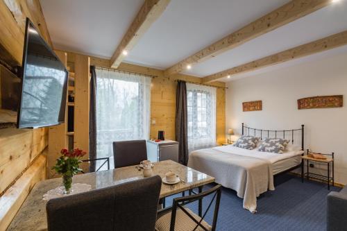 a bedroom with a bed and a dining room with a table at Pokoje i Apartamenty Centrum - Willa Bajeczka in Zakopane