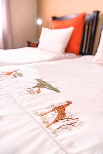a white bed with three animals on it at Chameleon Backpackers & Guesthouse in Windhoek