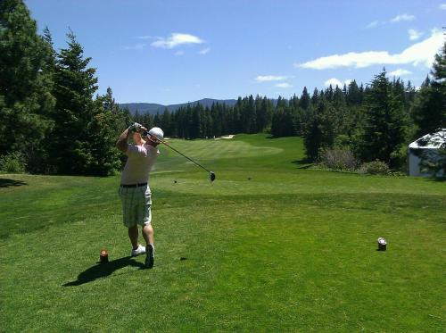 a man swinging a golf club on a golf course at Laholms Vandrarhem in Laholm