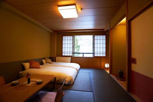 a bedroom with a large bed and a table at Meitoya So in Zao Onsen