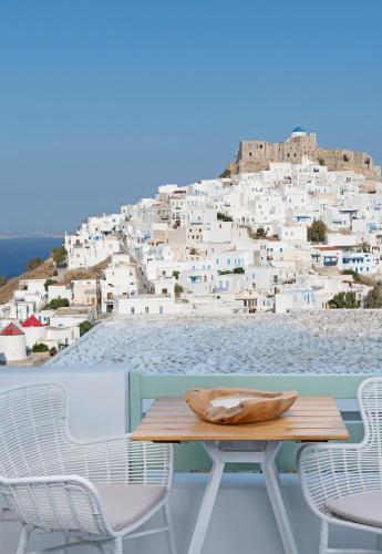 a table and chairs with a view of a city at Anatoli Luxury Studios & Suites in Astypalaia Town