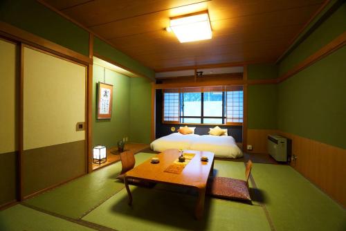 a bedroom with a bed and a table in it at Meitoya So in Zao Onsen