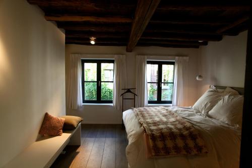 um quarto com uma cama grande e 2 janelas em Coeur Sablon em Bruxelas