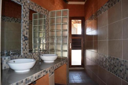 a bathroom with two sinks and a mirror at Antsanitia - Domaine du Mandravasarotra in Antsianitia