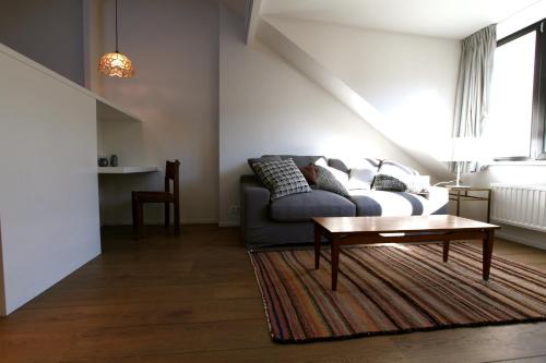 a living room with a couch and a coffee table at Coeur Sablon in Brussels