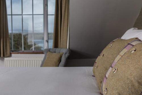 a bedroom with a bed with a pillow and a window at Greshornish House Hotel in Edinbane
