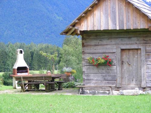 a wooden cabin with a picnic table and a large bell at Stangl - Hof in Bad Aussee