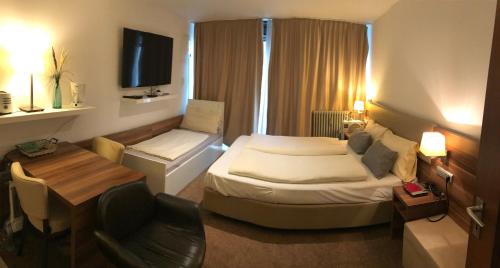ミュンヘンにあるMarsのベッド、テーブル、椅子が備わるホテルルームです。