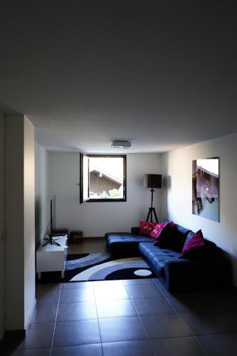 - un salon avec deux canapés bleus et une fenêtre dans l'établissement Chalet Kizuna, à Saint-Gervais-les-Bains