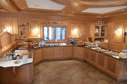 a large kitchen with wooden cabinets and a ceiling at Glasl's Landhotel in Zorneding
