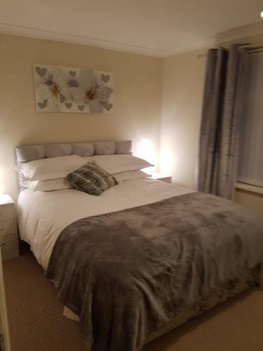 a bedroom with a large white bed with two lamps at LegenDerry B&B in Derry Londonderry