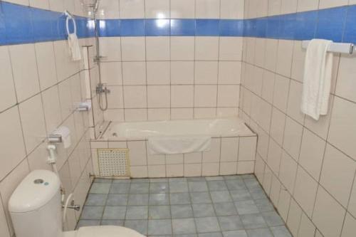 een badkamer met een toilet en een bad bij Hotel - Y in Douala