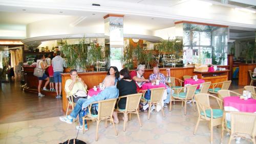 a group of people sitting at tables in a restaurant at Appartamento Guido Reni in Lido di Spina