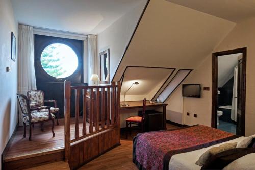 Schlafzimmer mit einem Bett, einem Schreibtisch und einem Fenster in der Unterkunft Palacio Arias in Navia