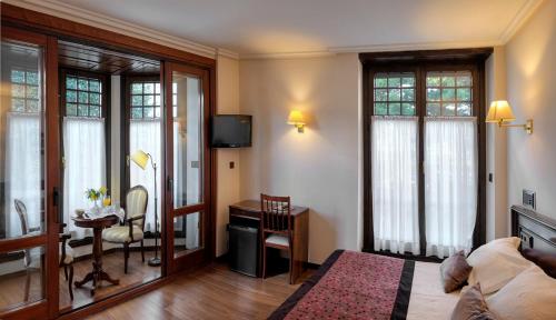 a living room with a bed and a desk at Palacio Arias in Navia