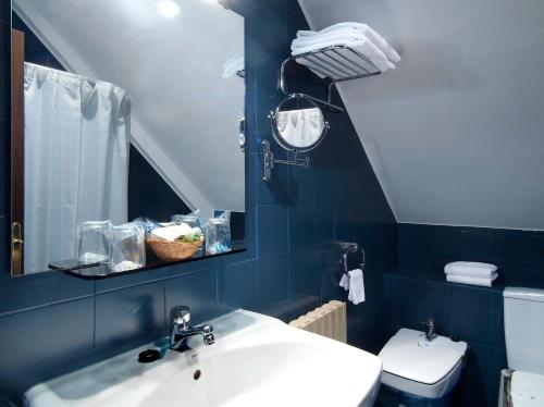 Baño azul con lavabo y aseo en Palacio Arias, en Navia