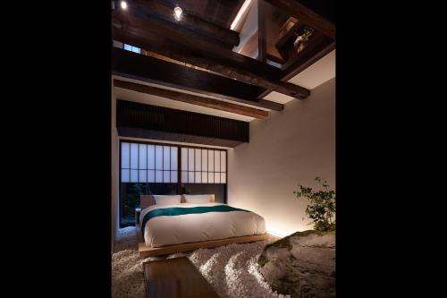 a bedroom with a bed and a large window at Kiraku Kyoto Honmachi in Kyoto
