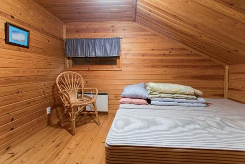 ピュハトゥントゥリにあるJänkäkolo Holiday Homeのベッド1台と椅子1脚が備わる客室です。