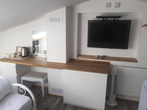 a kitchen with a desk with a tv on a wall at Barton Gate Farm B&B in Bude