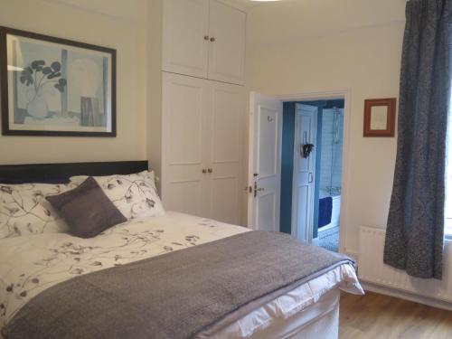 1 dormitorio con 1 cama y puerta que da a un pasillo en Garden Flat, Ealing, en Ealing