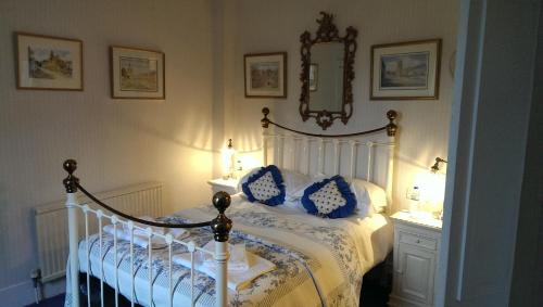 a bedroom with a white bed with blue pillows at The Inn at Fossebridge in Chedworth