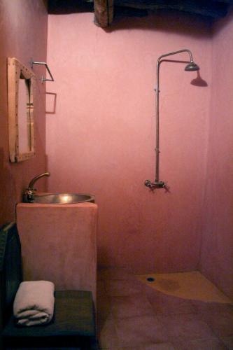 a bathroom with a sink and a shower with a lamp at kasbah timidarte in Zaouïta Bou Lhâssane