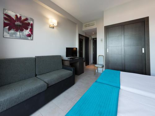 a living room with a bed and a couch at Pato Amarillo in Punta Umbría