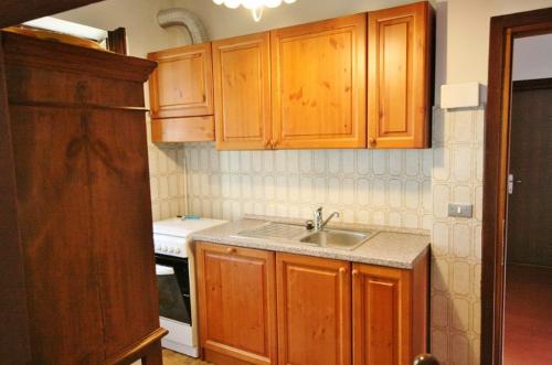 una cocina con armarios de madera y fregadero en Casa Iolanda, en Soraga