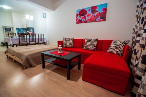 salon z czerwoną kanapą i stołem w obiekcie Apartment Šamorín w mieście Šamorín