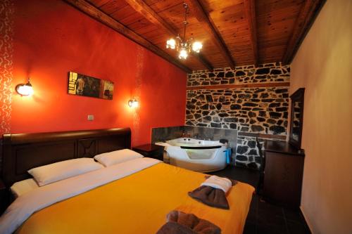 a bedroom with two beds and a bathroom with a sink at Enastron in Palaios Agios Athanasios