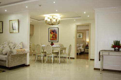 a dining room and living room with a table and chairs at Golden Prince Hotel & Suites in Cebu City
