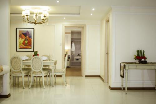 a white dining room with a table and chairs at Golden Prince Hotel & Suites in Cebu City