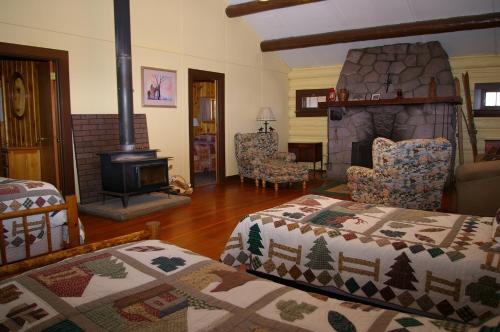 a living room with two beds and a fireplace at Parade Rest Ranch in West Yellowstone