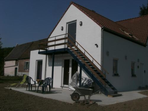 een wit huis met een trap aan de zijkant bij Ferme Lenfant Rez in Ville-Pommeroeul