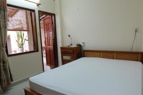 sypialnia z białym łóżkiem i oknem w obiekcie Moon house tropical garden - East side w mieście Nha Trang
