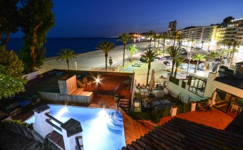 una vista aérea de una piscina con la playa en Villa Sa Caleta, en Lloret de Mar