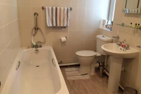 a bathroom with a tub and a toilet and a sink at Millbrook in Helston