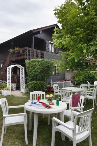 a group of white tables and chairs in a yard at HOTEL LES MARRONNIERS in Thonon-les-Bains