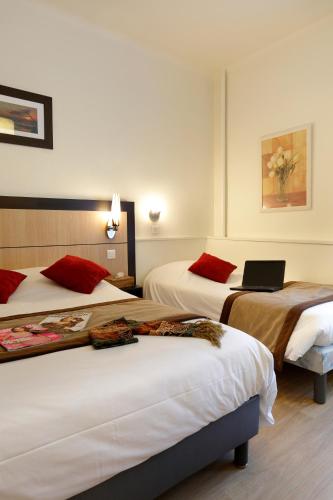 a hotel room with two beds with a laptop on top at HOTEL LES MARRONNIERS in Thonon-les-Bains