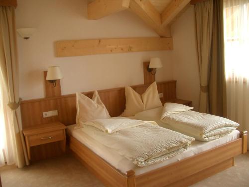 a bed with two pillows on it in a room at Hotel Gsieserhof in Valle Di Casies