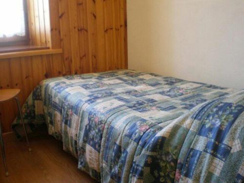 a bedroom with a bed with a quilt on it at Appartamento lerpino in Sappada