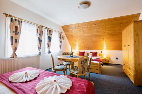 a hotel room with two beds and a table at Chalet Schäfer s vyhřívaným bazénem se slanou vodou in Harrachov