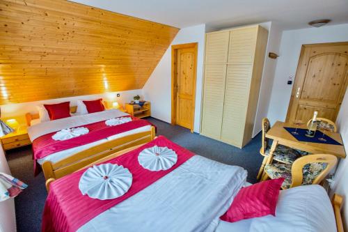 a bedroom with two beds with red and white sheets at Chalet Schäfer s vyhřívaným bazénem se slanou vodou in Harrachov