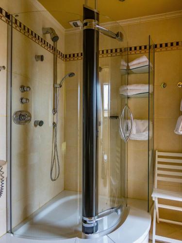 La salle de bains est pourvue d'une douche et d'une baignoire. dans l'établissement LOGIS - Belle Hôtel, Lille-Ouest, à Bailleul