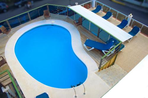 a swimming pool with blue chairs and a swimming pool at Anton Reef in Sosúa