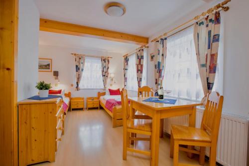 a living room with a table and chairs and a couch at Chalet Schäfer s vyhřívaným bazénem se slanou vodou in Harrachov