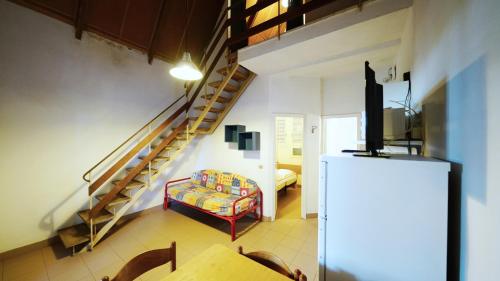 a living room with a spiral staircase and a couch at Bungalow Logonovo in Lido di Spina