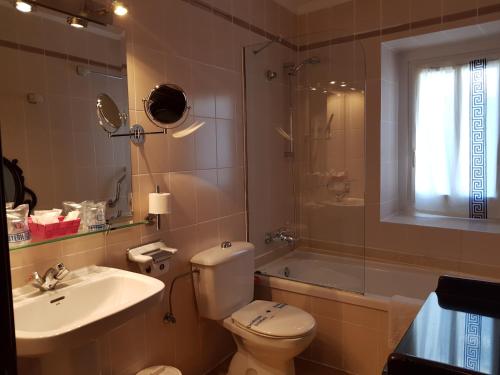
a bathroom with a toilet, sink, and shower at Hotel La Residencia in Cadaqués

