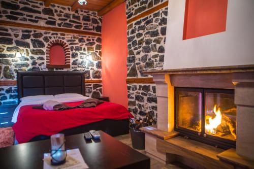 a room with a fireplace and a bed in it at Enastron in Palaios Agios Athanasios