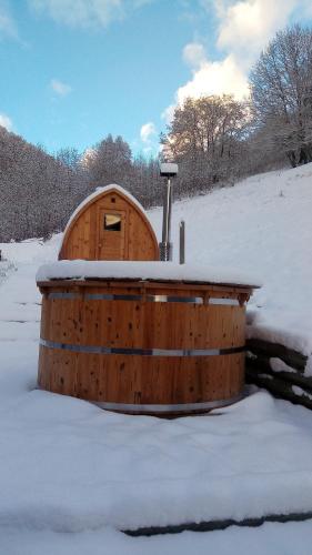 a wooden hot tub in the snow with snow at Nuit a Pleiney in Saint-Rhémy-en-bosses